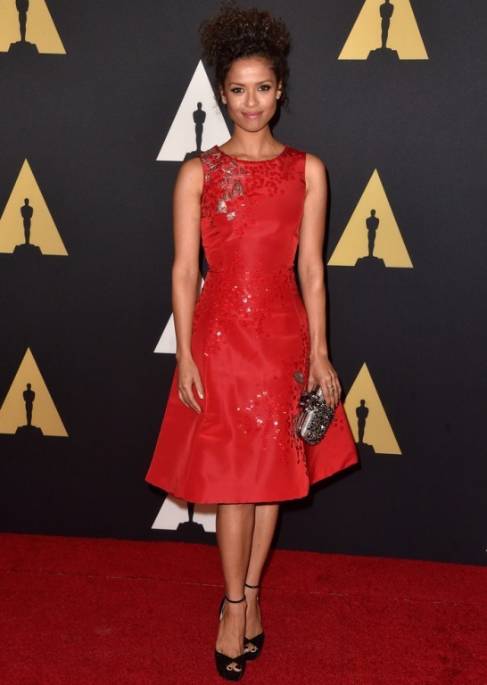 Splurge: Gugu Mbatha-Raw’s 2014 Governors Awards Oscar de la Renta Red Bell Shape Beaded Dress, Embellished Satin Box Clutch, and Jimmy Choo Black Peep Toe Ankle Strap Sandals