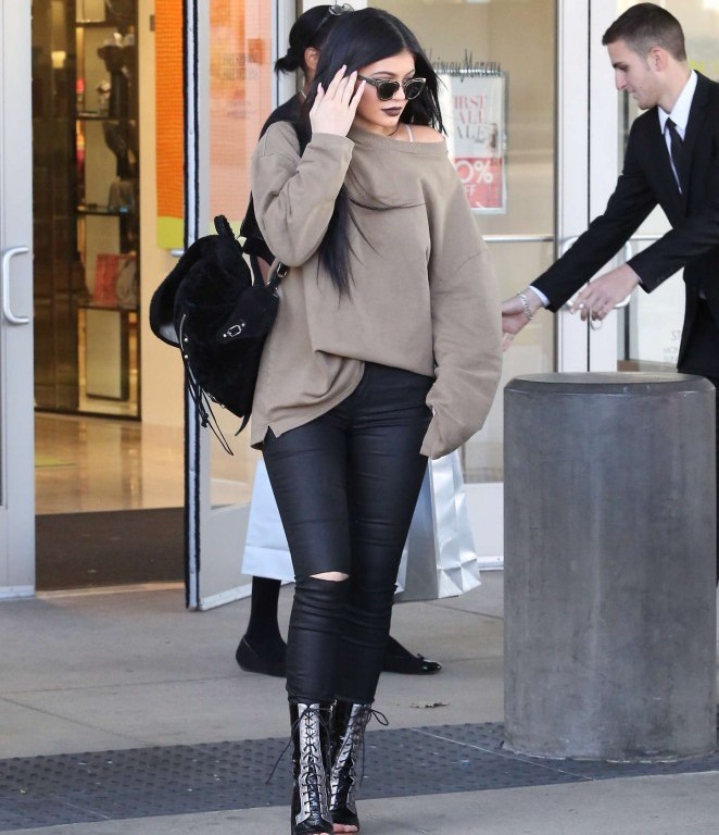 Get the Look: Kylie Jenner’s Woodland Hills Mall Dior Gold Chromic Sunglasses, Kanye West x Adidas Fossil Crew Sweatshirt, Frame Vian Le Skinny Satine Jeans, Rodarte Embossed Crocodile Leather Lace Up Lucite Heel Boots, and Balenciaga Classic Suede Traveller Backpack