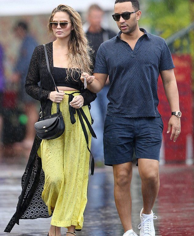 Get the Look: Chrissy Teigen’s Hawaii Dior Metallic Sunglasses, Nookie Black Sheer Wrap Maxi Dress, Proenza Schouler Printed Cotton and Silk Blend Wide Leg Pants, Chloe Georgia Mini Leather Shoulder Bag, and Ancient Greek Chrysso Beaded Leather Sandals
