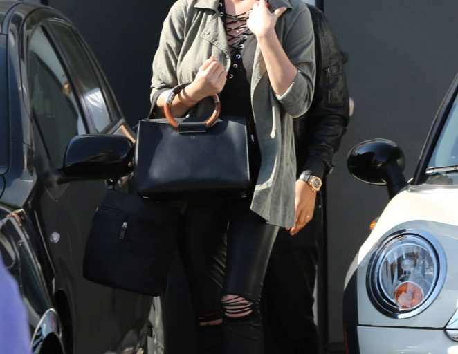 Splurge: Chrissy Teigen’s Los Angeles Rails Sage Nadia Trench, IRO Black Tissa Lace Up Tank, and The Row Round Handle Tote Bag