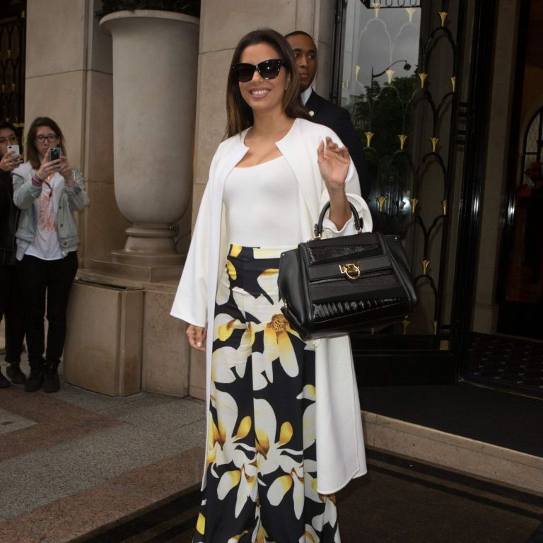 Get the Look: Eva Longoria’s Four Seasons Hotel George V Dior Mohotani Sunglasses, Wolford Jamaika Stretch Jersey Bodysuit, alice + olivia Athena Super Flare Pants, Salvatore Ferragamo Sofia Bag, and Gianvito Rossi Portofina Sandals