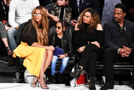 Get the Look: Beyonce’s All Star Weekend J.W. Anderson Logo Hoodie, Jacquemus Yellow Asymmetrical Skirt, Gentle Monster Sunglasses, and Gianvito Rossi Plexi Lace Up Heels