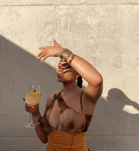 Kylie Jenner Accused of Not Supporting Black Brands for Not Tagging Black British Brand Loud Brand Studios Orange and Brown Slash Asymmetric Halter Mini Vashtie Dress