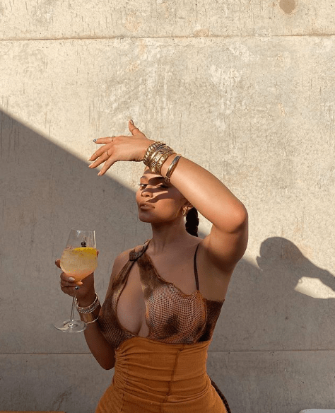 Kylie Jenner Accused of Not Supporting Black Brands for Not Tagging Black British Brand Loud Brand Studios Orange and Brown Slash Asymmetric Halter Mini Vashtie Dress