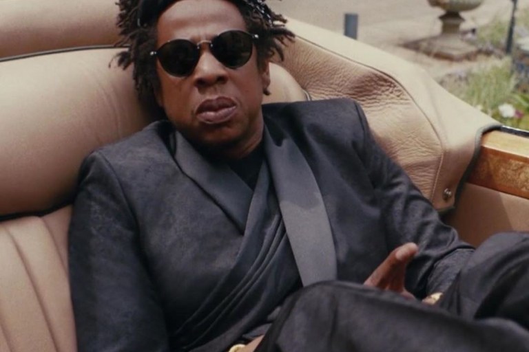 Jay Z ‘s Black is King Looks Were Fire: His Draped Black Dior Fall 2019 Suit, Red Givenchy Look, Sergio Tacchini Polo, Lisa Eisner Chain, and More, Styled by June Ambrose