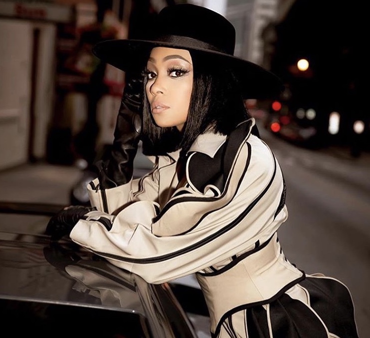 Splurge: Monica’s Pre Verzuz Battle Tan and Black Robert Wun Ruffled Shoulder Belted Trench Coat, Saint Laurent Boots and Christian Siriano Hat