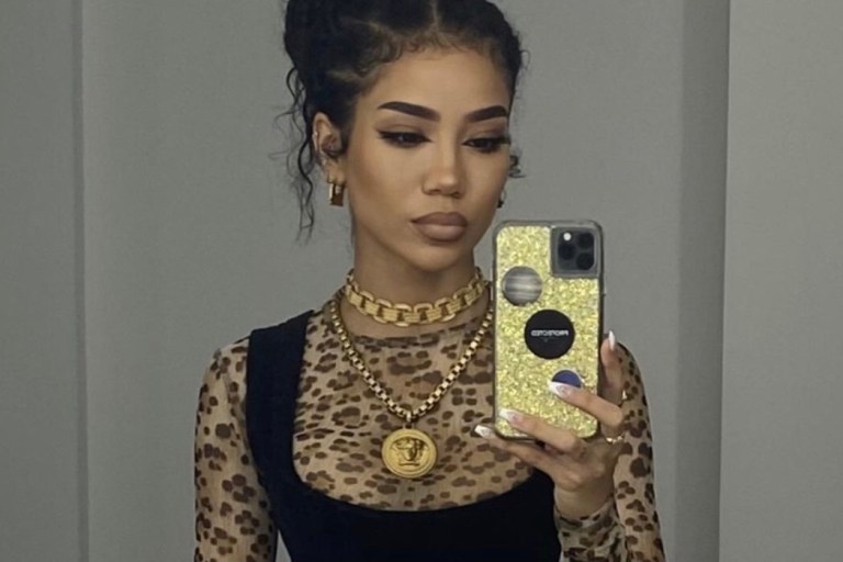 Jhené Aiko Posed In Vivienne Westwood Mini Dress, R13 Top, and Versace Jewelry For a Shoot