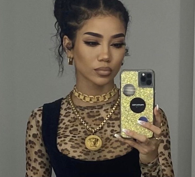 Jhené Aiko Posed In Vivienne Westwood Mini Dress, R13 Top, and Versace Jewelry For a Shoot