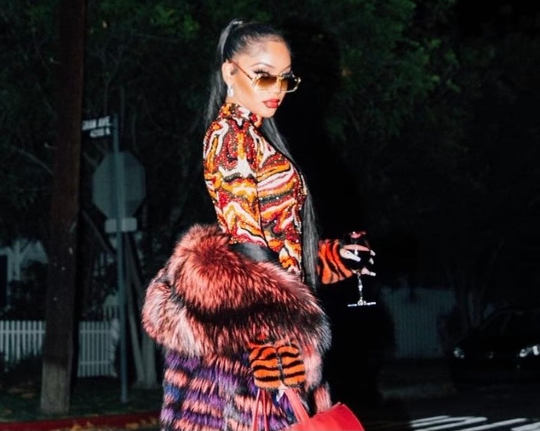 Saweetie Brought In the New Year in Elie Madi Multicolor Leopard Print Dress, Red Large Telfar Bag, For Stars Fashion House Fur Coat, Natalie Mills Earrings, and Red ALEVí Milano Velvet Pumps