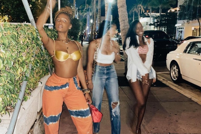 Shateria’s Vacation Isa Boulder Gold Bikini Top, Alberta Ferretti Orange and Green Tie Dye Pants, and Attico Orange Block Heel Mules