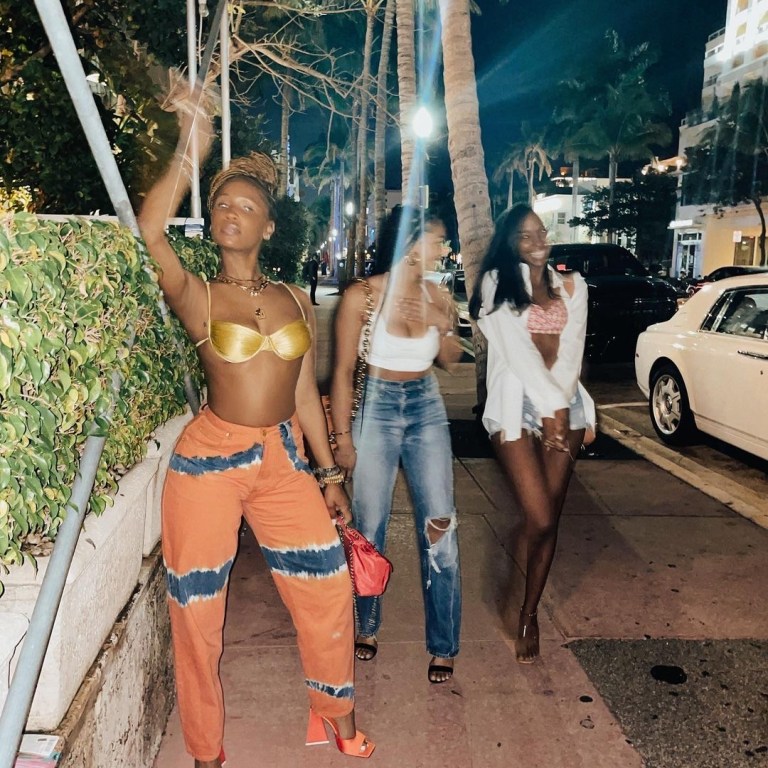 Shateria’s Vacation Isa Boulder Gold Bikini Top, Alberta Ferretti Orange and Green Tie Dye Pants, and Attico Orange Block Heel Mules