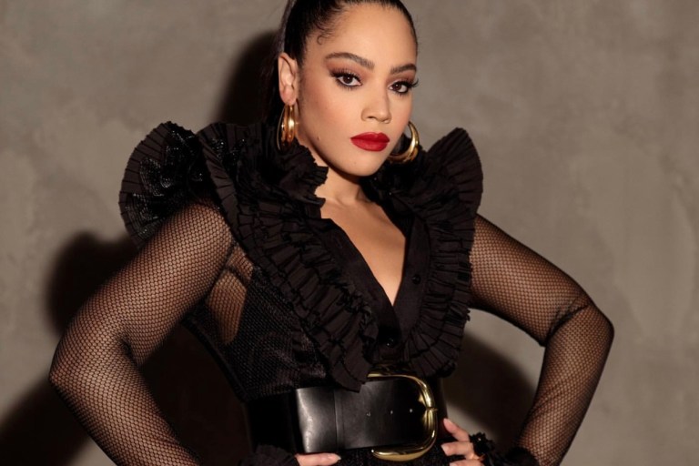 Bianca Lawson Posed for an Shoot Wearing a UNTTLD Black Ruffled Fishnet Mesh Dress With Berna Peci Gold Hoops and Nasty Gal Accessories