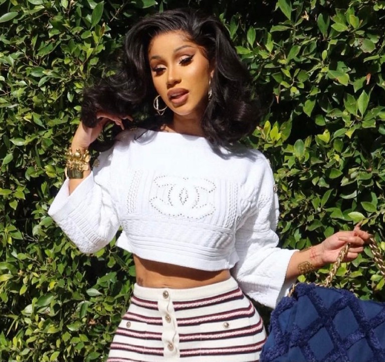 Cardi B Is Spring-Ready in Chanel Cruise 2021 Look Including White Cable Knit Logo Sweater, Striped Knit Button Mini Skirt and Navy Cotton Canvas and Calfskin Flap Bag