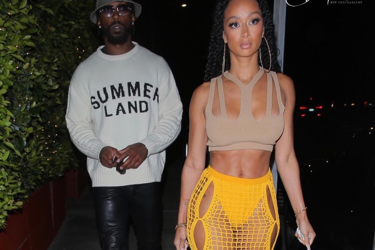 Draya Michele Spotted in Dion Lee Tan Knit Cutout Crop Top and Yellow Crochet Skirt During Outing With Tyrod Taylor in Nahmias Sweater, 1017 ALYX 9SM Black Leather Pants, Celine Plaid Bucket Hat and Rick Owens Sneakers