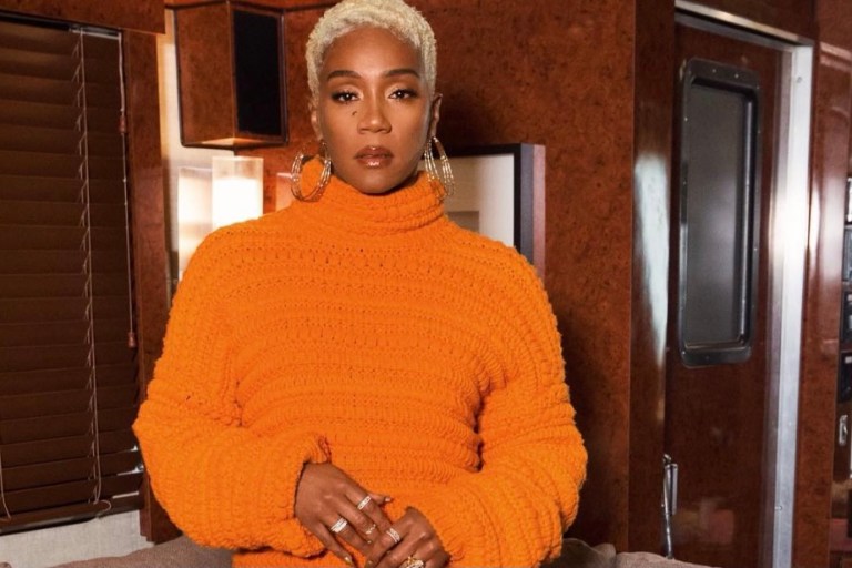 Tiffany Haddish Radiates in Orange Crochet Knit Sweater and Hand-Knotted Fringe Skirt by Christian Wijnants and Stuart Weitzman Gold Sandals