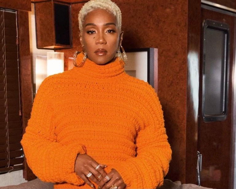 Tiffany Haddish Radiates in Orange Crochet Knit Sweater and Hand-Knotted Fringe Skirt by Christian Wijnants and Stuart Weitzman Gold Sandals