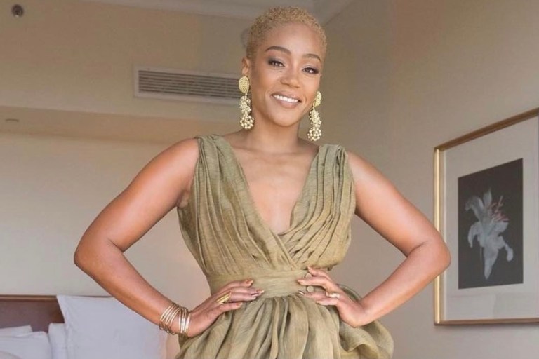 Tiffany Haddish Wows in Altuzarra Olive Green Draped Linen Dress, Vintage Ebony Fashion Fair Earrings and Gold Jimmy Choo Sandals