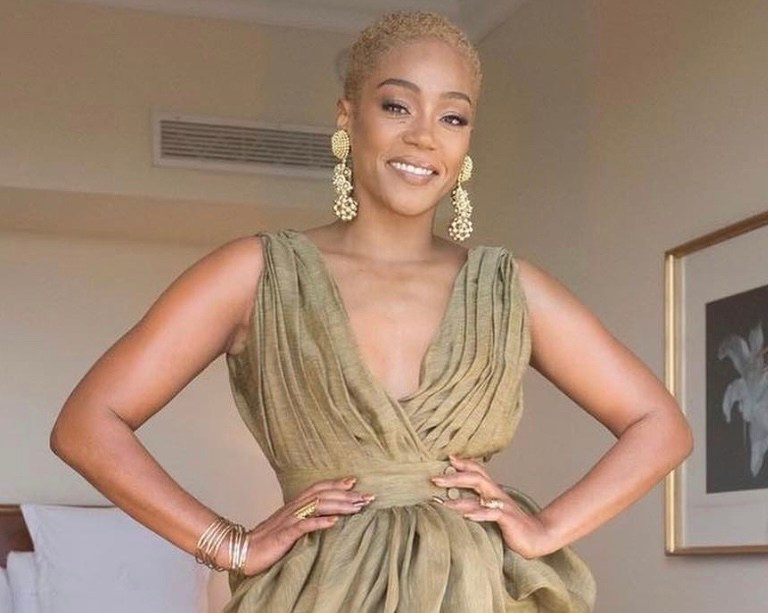 Tiffany Haddish Wows in Altuzarra Olive Green Draped Linen Dress, Vintage Ebony Fashion Fair Earrings and Gold Jimmy Choo Sandals