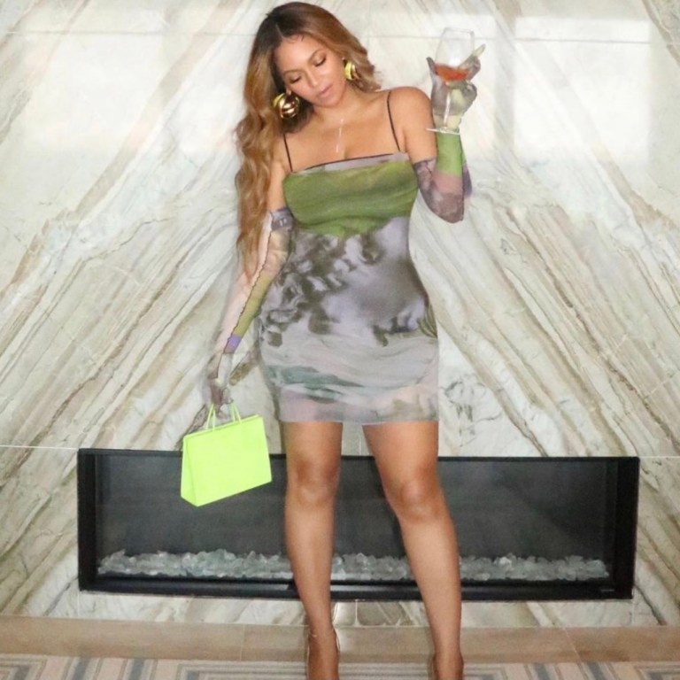 Beyoncé Lives It Up in Miami Wearing Auné Green Sculpture Print Mini Dress and Matching Gloves Paired with Jacquemus Green Structured Sequin Pumps and Medea Neon Green Suede Bag