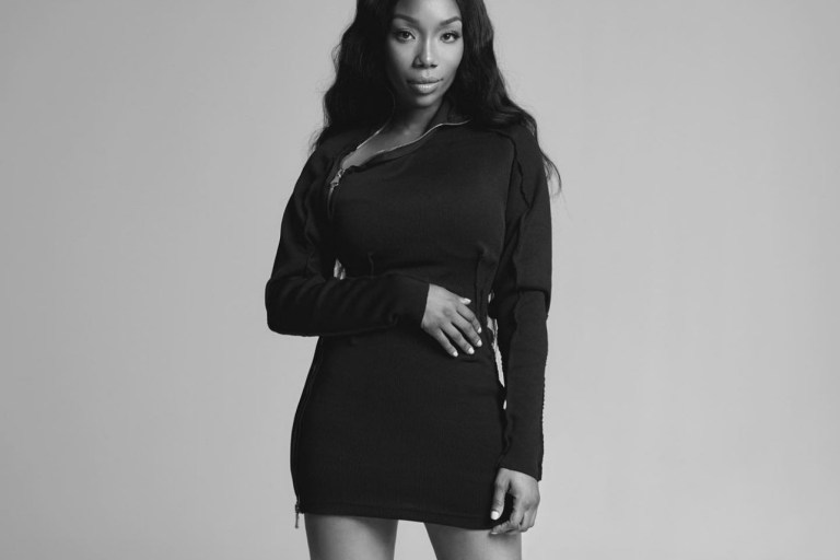 Brandy Stuns in Black and White Photoshoot Wearing Lionne Clothing Black Long Sleeve Zip-Up Mini Dress and Femme LA Black Lace-Up Sandals