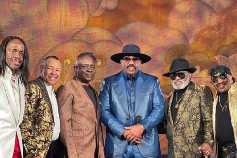 Earth, Wind & Fire and The Isley Brothers Verzuz TV Fashion: Verdine White in Custom Richfresh White and Red Suit, Ron Isley in Dolce and Gabbana Metallic Jacquard Suit, Ernie Isley in For The Stars Fashion House White Gold-Studded Leather Jacket + More