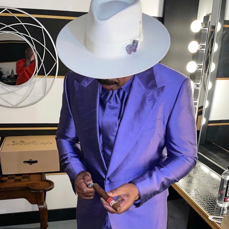 Steve Harvey Hosts Verzuz Between Earth, Wind & Fire and the Isley Brothers Wearing Dolce and Gabbana Custom Purple Satin Suit and Meshika White Hat