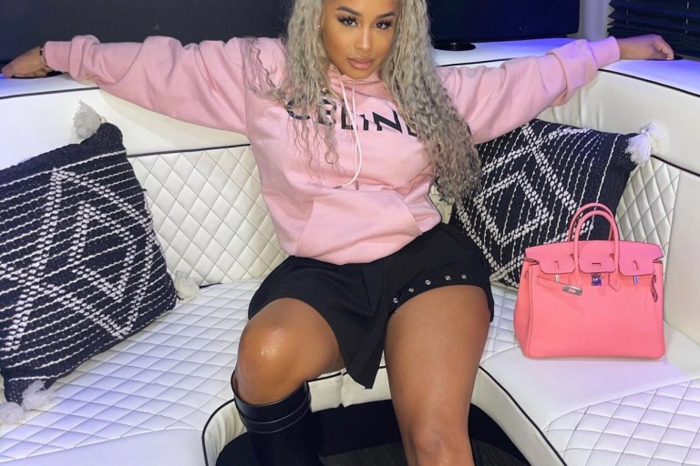 DreamDoll Keeps It Chic in a Black Buckle Pleated Skirt by Fashion Nova