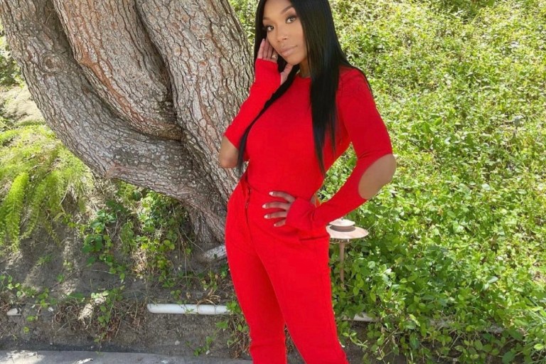 Brandy Gives Us a Style Moment in Givenchy Red Spring 2021 Look Including Open-Back Elbow Cutout Long Sleeve Bodysuit and Skinny Leg Pants