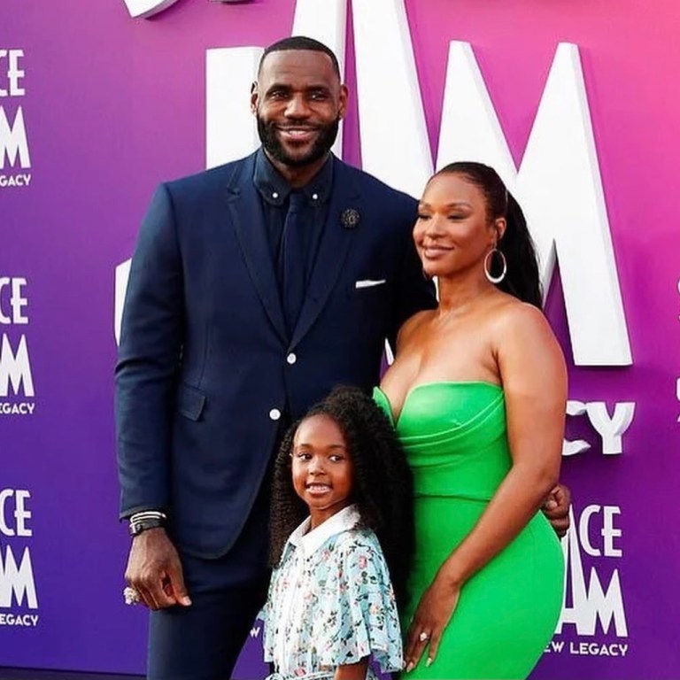 Savannah James Goes Green at the ‘Space Jam: A New Legacy’ Premiere with LeBron and Zhuri James Wearing Alex Perry Green Strapless Midi Dress and Amina Muaddi Green Lace-Up Sandals