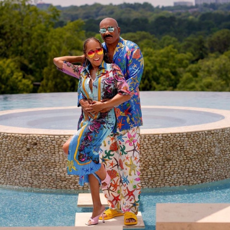 The Harvey’s Celebrate the Fourth of July in Style Wearing Versace Looks With Steve Harvey in a Starfish Print Pajama Shirt and Pants and Marjorie Harvey in a Pleated Dress and Pink Plisse Mules by the Brand