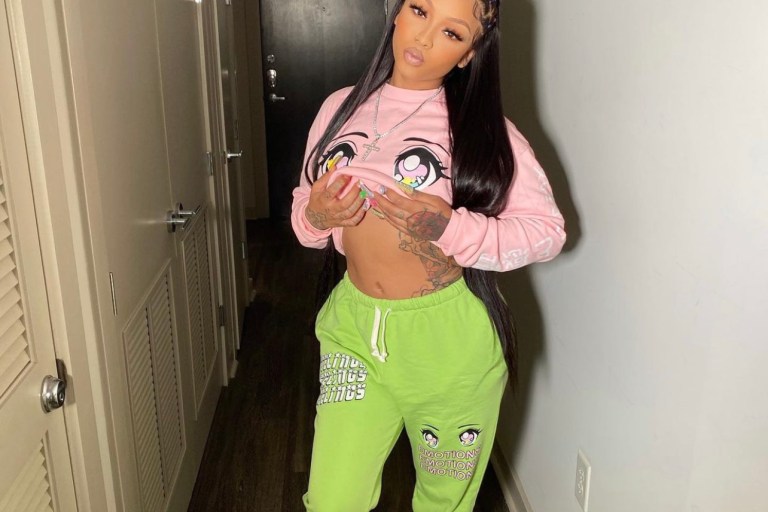 Cuban Doll Keeps It Cozy in Fashion Nova Graphic Pink Sweatshirt and Green Sweatpants