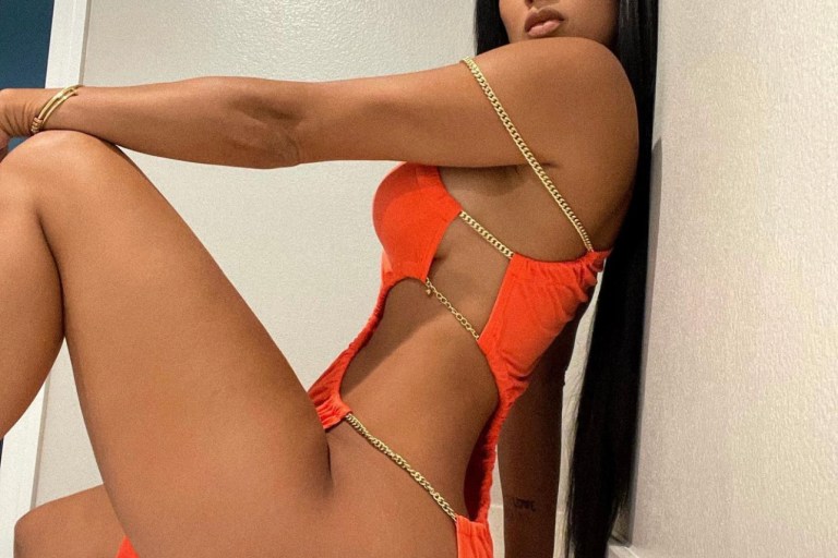 Draya Michele Shows Off Her Figure in Fashion Nova Orange One Shoulder Chain Strap Dress