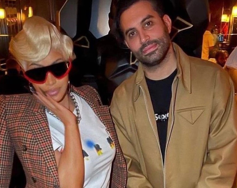 Cardi B Visits Cesar Restaurant in Paris Wearing Balenciaga Checked Tailored Coat, Marni White Logo T-Shirt, Red Sweatpants, and Cardi B x Reebok Red Sneakers