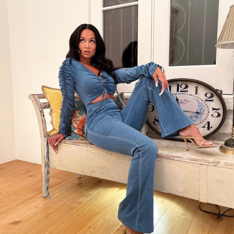 Draya Michele Poses While Rocking a Denim Cutout Wide Leg Jumpsuit From Fashion Nova