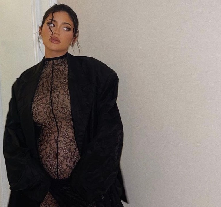 Kylie Jenner Shows Off Her Baby Bump in LaQuan Smith Spring 2022 Black Lace Catsuit and Wrap Skirt While Attending the Designer’s NYFW Show