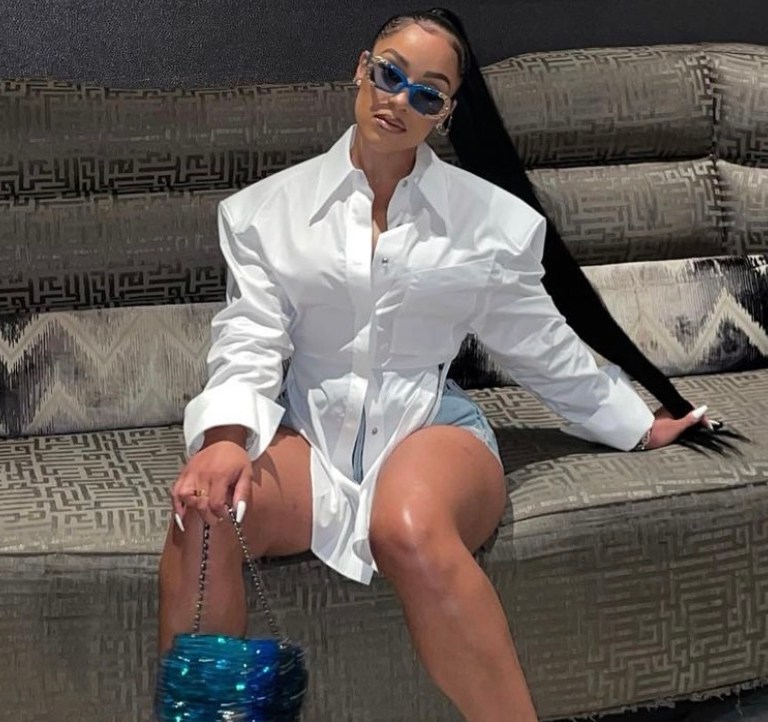 Most Requested: Joie Chavis Continues Her Birthday Celebration With Recent Outing Wearing Mugler White Structured Open Back Top and Denim Shorts Paired With Bottega Veneta Wire Sandals and Crystal Chanel Handbag