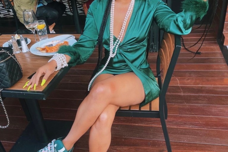 Tommie Lee Wears Green Feather Trim Satin Dress by Fashion During Latest Outing
