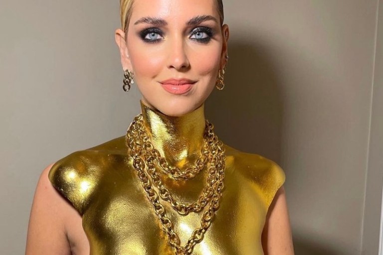 Chiara Ferragni Receives the GQ Woman of the Year Award Wearing Schiaparelli Look Including Gold Padlock Necklace Bust Top, Black Wide Leg Pants, and Gold-Painted Toe Detail Satin Pumps