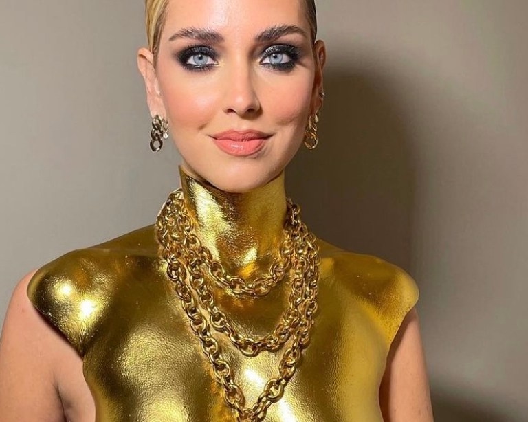 Chiara Ferragni Receives the GQ Woman of the Year Award Wearing Schiaparelli Look Including Gold Padlock Necklace Bust Top, Black Wide Leg Pants, and Gold-Painted Toe Detail Satin Pumps