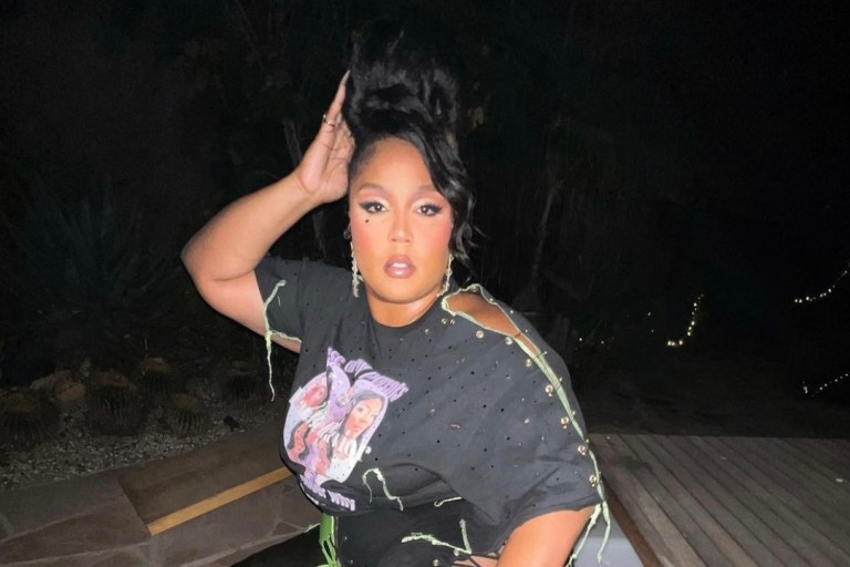 Lizzo Attends Harry Styles’ Concert in LA Wearing Stinson Haus Look Including Custom Fan Behavior Distressed T-Shirt and Lace-Up Pants