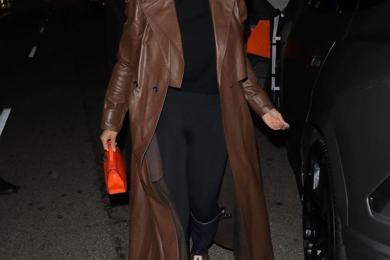 Lori Harvey Grabs Dinner in Beverly Hills Wearing Bottega Veneta Brown Leather Trench Coat, Wolford Black Top and Leggings and Louis Vuitton Colorblock Knee-High Wedge Boots