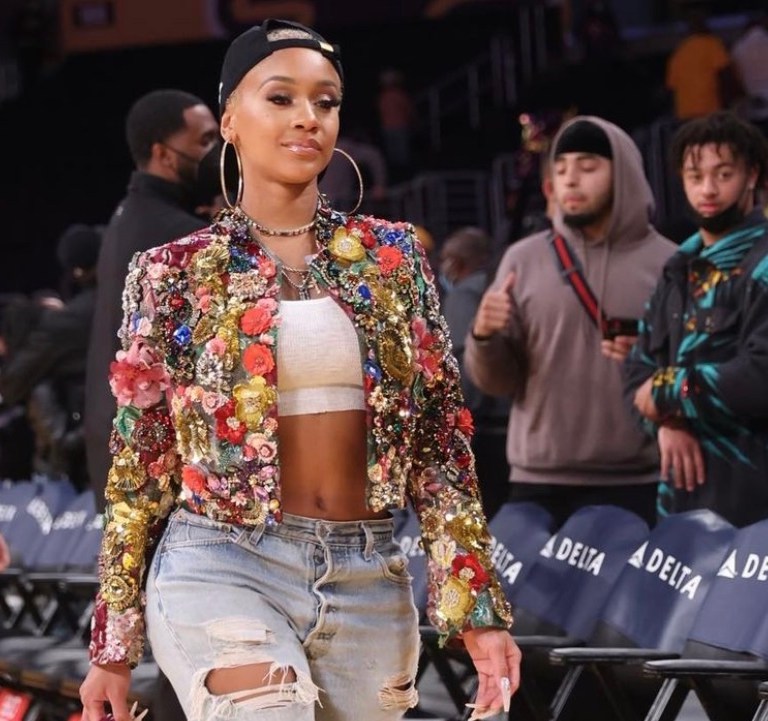 Wardrobe Inquiry: Saweetie Attends Lakers vs. Timberwolves Game in LA Wearing Dolce and Gabbana Embellished Jacket and Pink Heels Paired with White Crop Top, Distressed Jeans and Goodie Black Hat