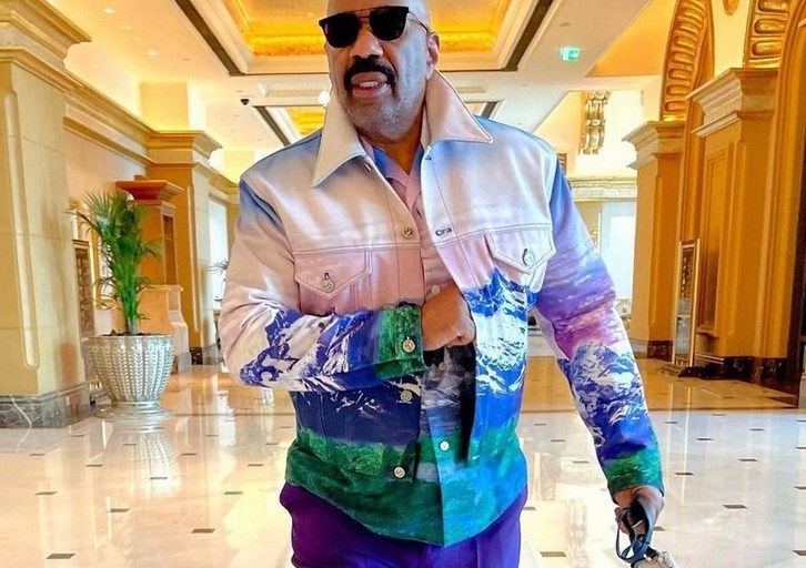 Steve Harvey Steps in Abu Dhabi Styled in a Louis Vuitton x Virgil Abloh Purple and Green Landscape Jacket and Matching Shirt