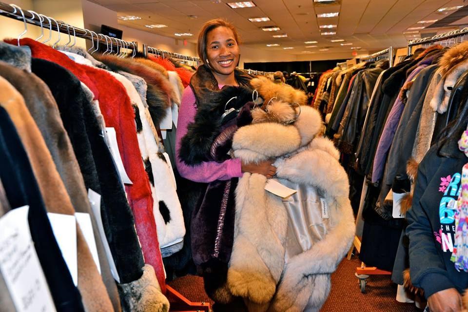 A person holding a bunch of furs at a Mano Swartz Unclaimed Fur Sale

