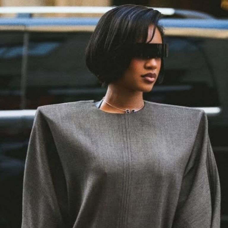 Milan Fashion Week: Saweetie attended the MM6 Maison Margiela Runway Show in a Gray Structured Dress with Black Gloves and Tan Boots